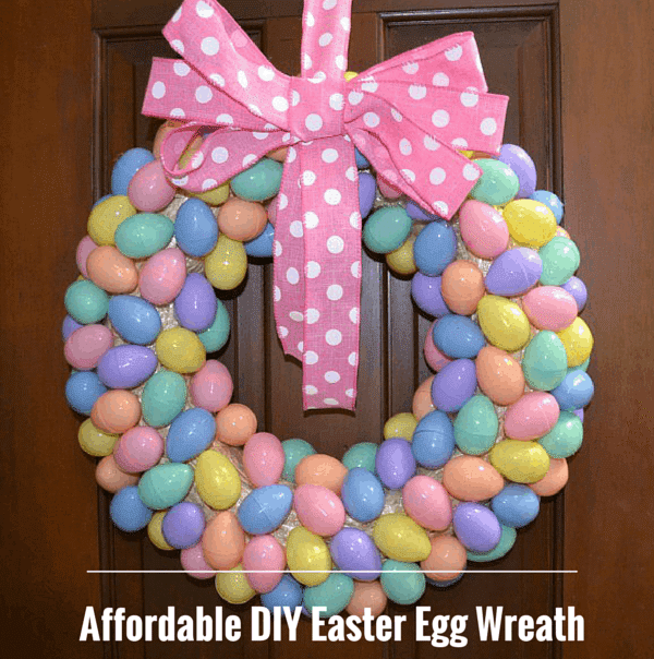 diy wreath made of colorful pastel easter eggs with a pink polka dot bow hanging on a door. 