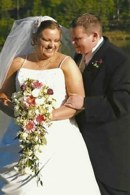 outdoor wedding photo of husband and wife on wedding day holding a bouquet of flowers